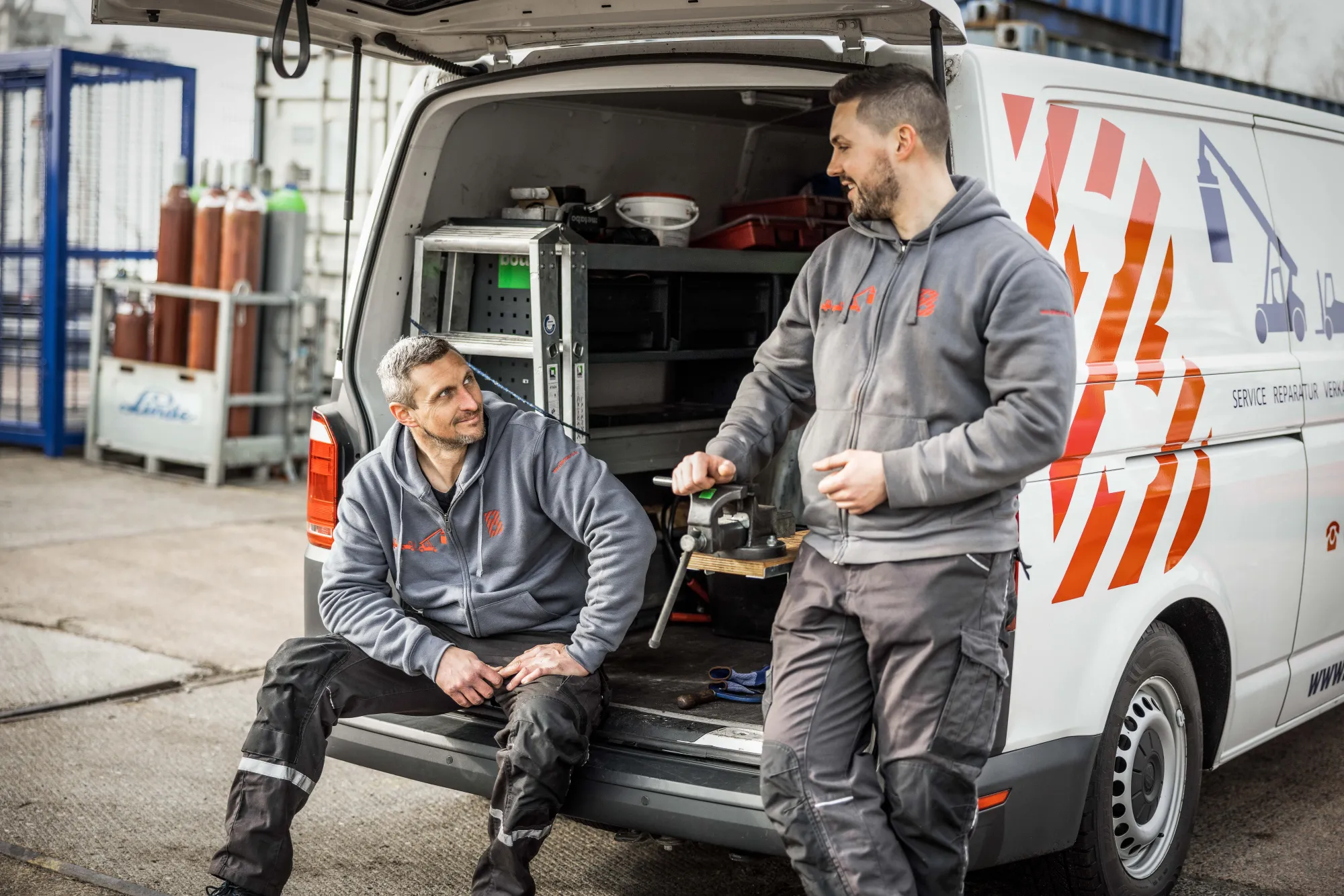 Zwei Servicetechniker am geöffneten Laderaum eines Servicewagens