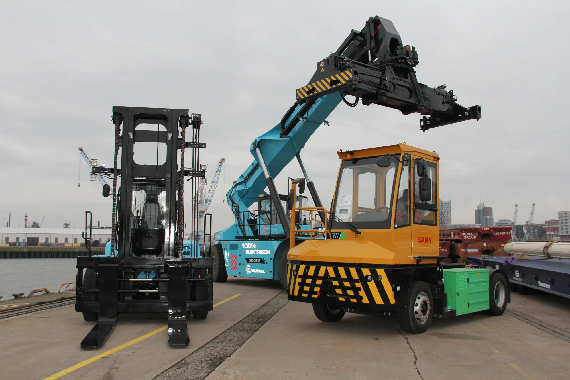 Carretilla elevadora, reachstacker y cabeza tractora amarilla en el muelle del puerto